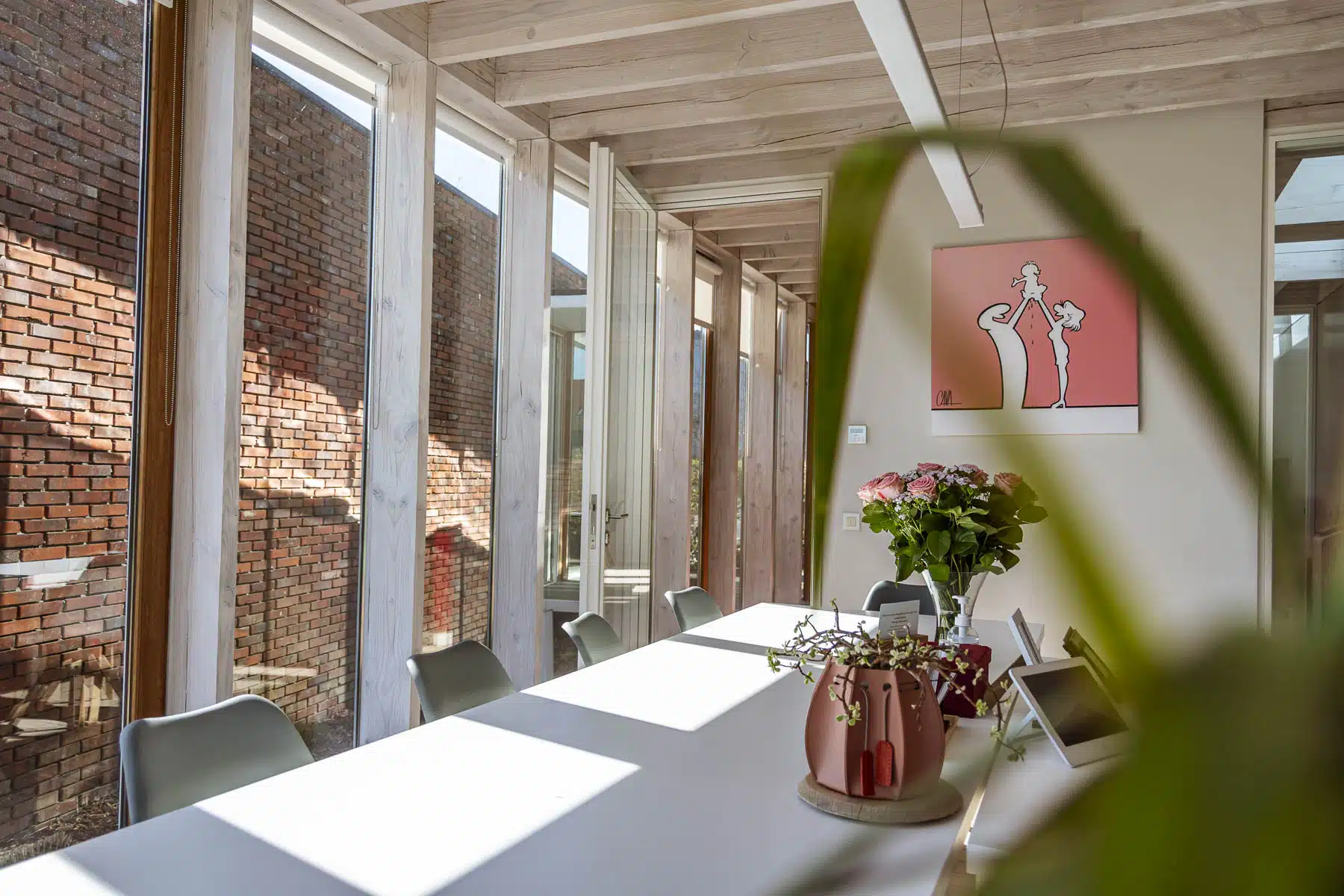 Modern kantoor van Notariaat Horebeke met vergadertafel, houten balken en bakstenen muur