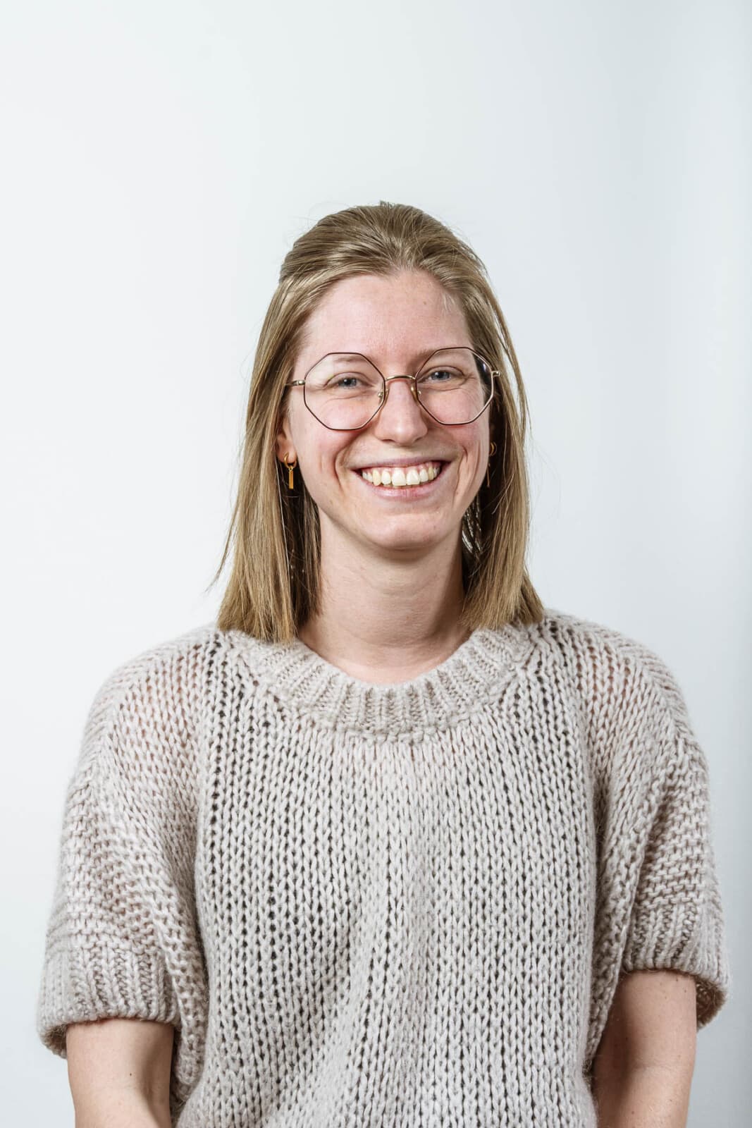 Megan Delfosse, dossierbeheerder bij Notariaat Horebeke, lacht vriendelijk in beige gebreide trui en bril
