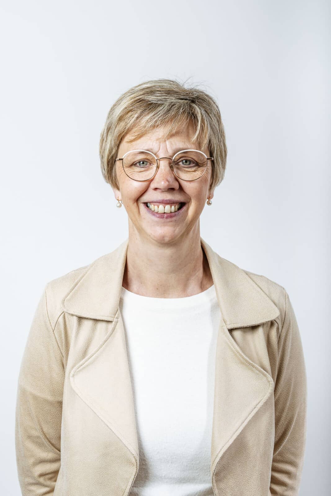 Portretfoto van Anja Snoeck, notarieel medewerker bij Notariaat Horebeke, glimlachend met bril en beige jasje