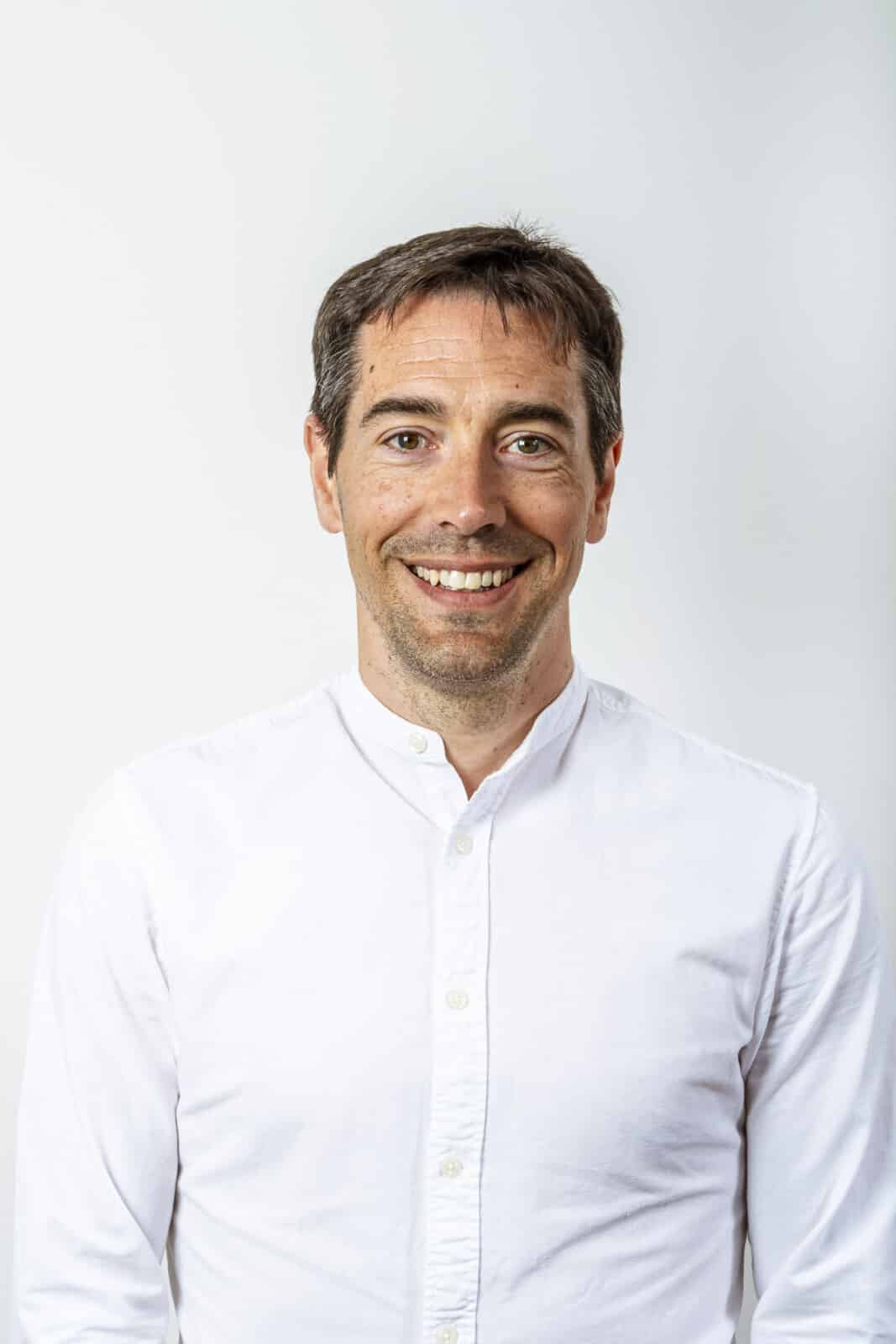 Kenny Huysman, secretariaat medewerker van Notariaat Horebeke, glimlachend in wit overhemd